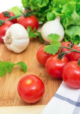 domates, soğan, sarımsak, marul ve nane bir ahşap tahta ve bir havlu üzerinde Şubesi