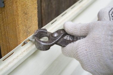 Hand with pliers take out a nail