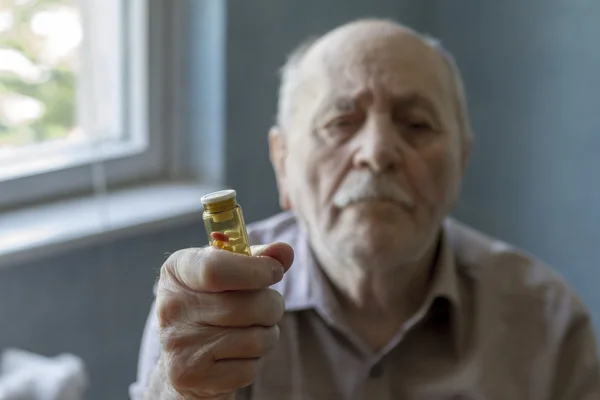 Старий тримає таблетки — стокове фото