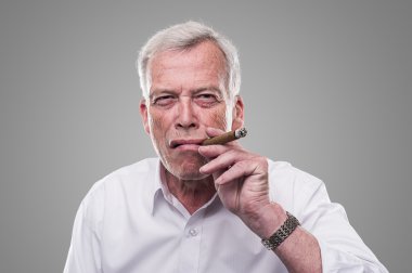 Handsome senior smoking a cigar clipart