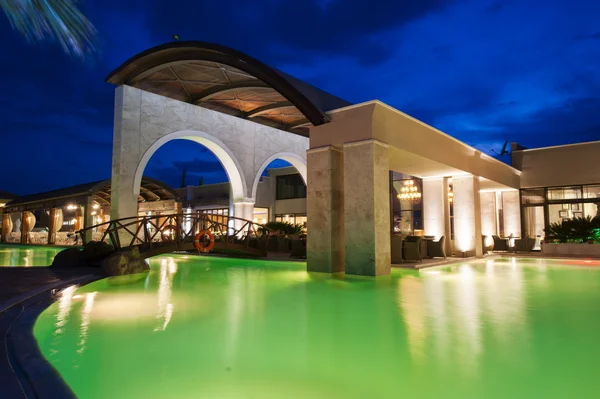 Нічний басейн із багатим готелем — стокове фото