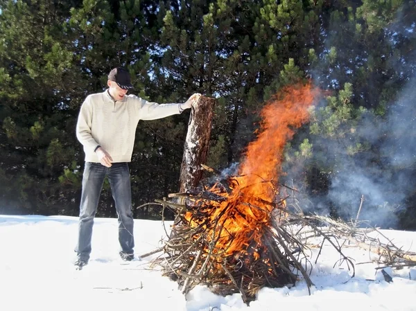 O homem e a fogueira no meio da floresta — Fotografia de Stock