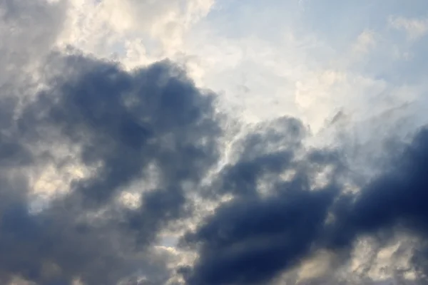 Blauwe hemel en zware wolken en de zon achter — Stockfoto