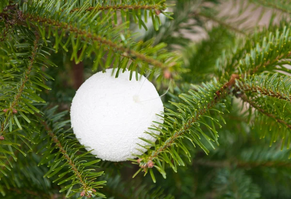 Witte kunststof sieraad op kerstboom — Stockfoto