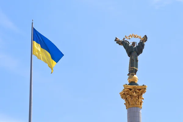Ukrainska flagga och monument till berehynia i kiev — Stockfoto