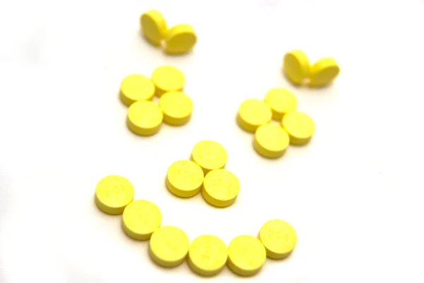 Comprimidos amarelos em branco — Fotografia de Stock