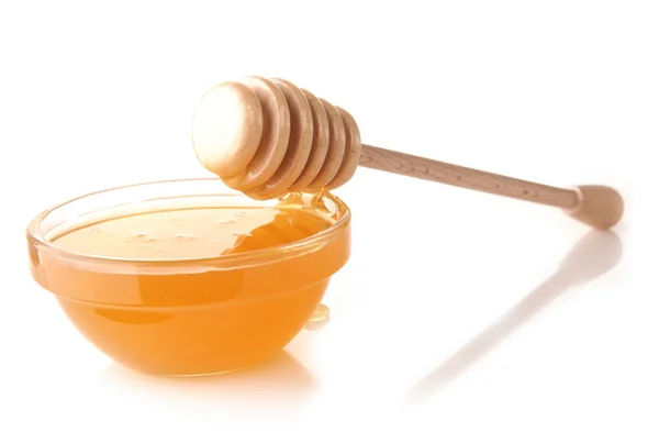 stock image Honey pouring from drizzler into the bowl. Bowl is on a white