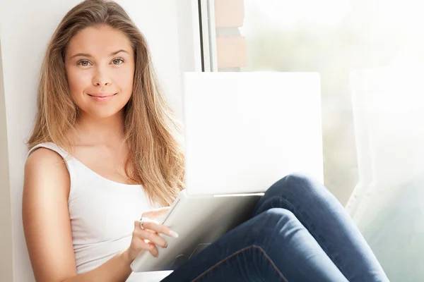Meisje met computer aan raam — Stockfoto
