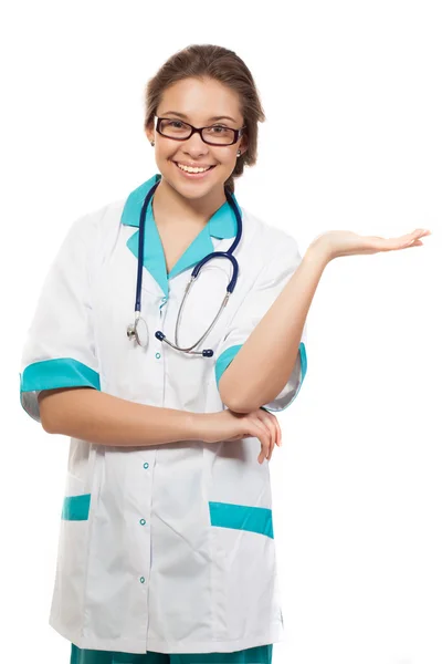 Jovem médica apresentando e mostrando espaço de cópia para produto ou texto. Profissional médico feminino caucasiano isolado em fundo branco . — Fotografia de Stock