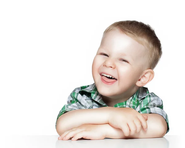 テーブルに坐っている間笑みを浮かべて、かわいい男の子の肖像画です。 — ストック写真