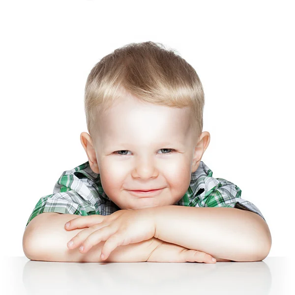 Πορτρέτο του ένα χαριτωμένο μικρό αγόρι χαμογελά ενώ κάθεται στο τραπέζι, είναι — Φωτογραφία Αρχείου