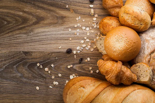 Assortment of baked bread on wood table Stock Image