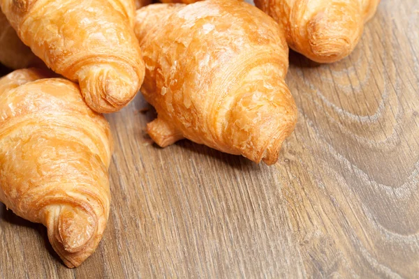 Croissants on a wooden background with copyspace — Stock Photo, Image