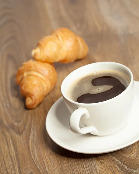Café da manhã com café e croissants em uma cesta na mesa — Fotografia de Stock
