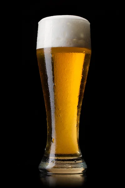 Bier ins Glas auf schwarz lizenzfreie Stockfotos