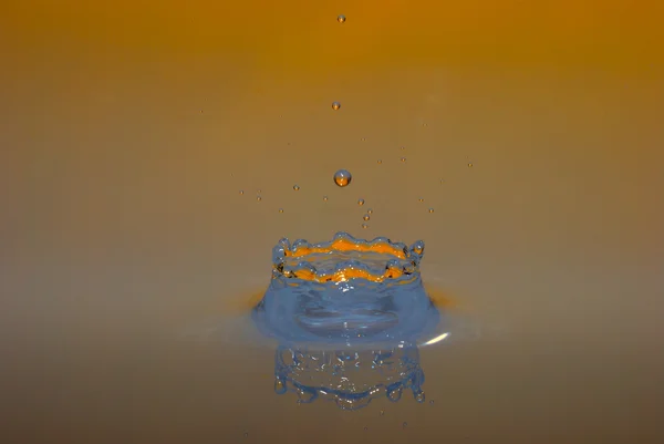 Gotas que impactam laranja — Fotografia de Stock