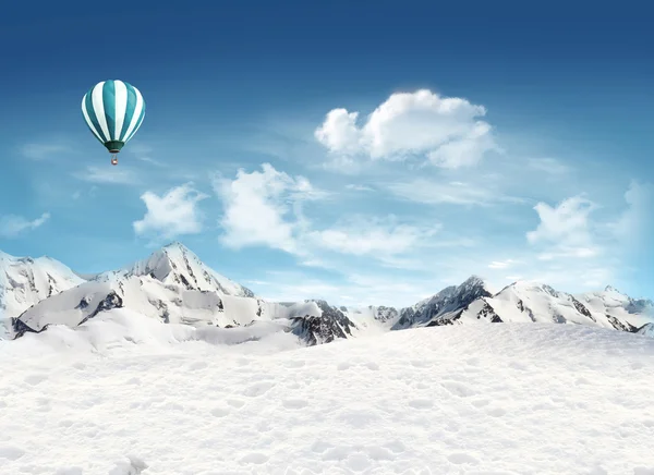 Гірський пейзаж зі снігом і повітряною кулею, що летить в с — стокове фото