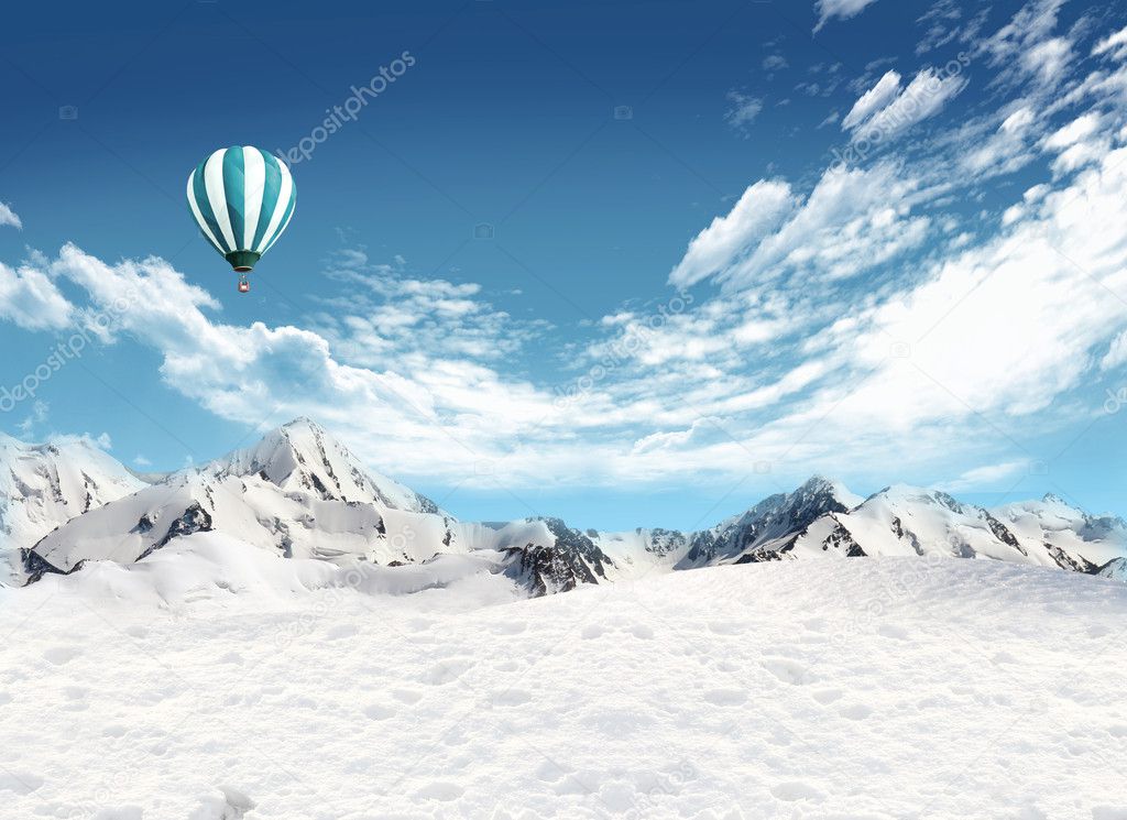 Mountain landscape with snow and hot air balloon flying in the s