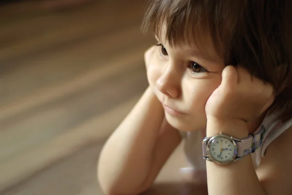 Un hermoso bebé caucásico yace con el reloj —  Fotos de Stock