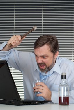 A businessman sits and breaks your computer clipart