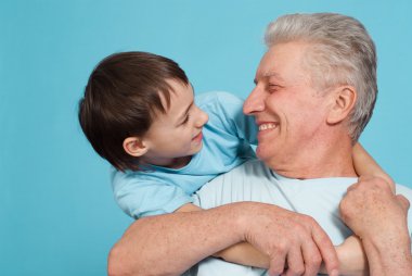 Happy pretty Caucasian grandfather with his grandson fooled