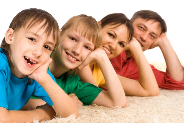 Ładny rodziny, leżąc na dywanie — Zdjęcie stockowe