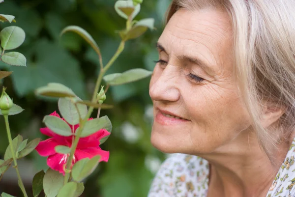Mujer envejecida con flor —  Fotos de Stock