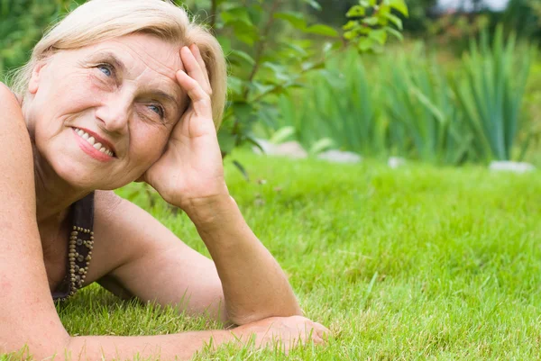 Old woman on grass — Stock Photo, Image