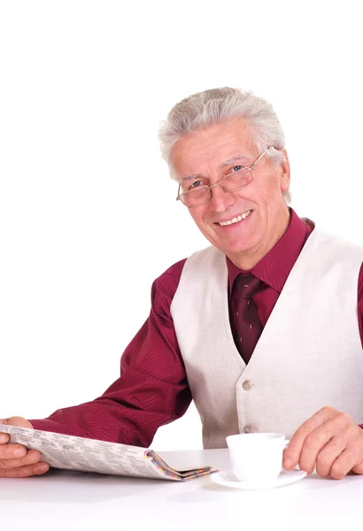 Handsome caucasian good man sits at a table with a newspaper — Stock Photo, Image