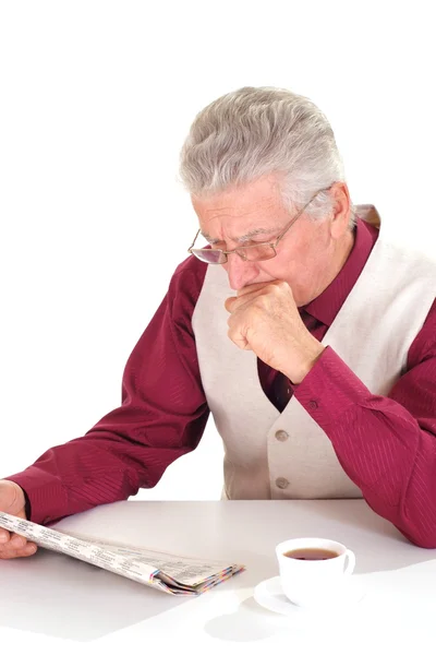 Handsome caucasian nice aged male sits at a table with a newspap — Stock Photo, Image