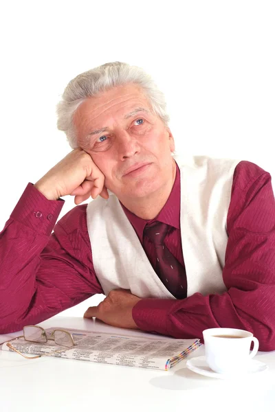 Handsome caucasian happy elderly man sits at a table with a news — Stock Photo, Image