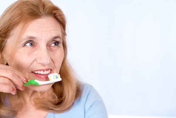 Yaşlı kadın diş fırçalama — Stok fotoğraf