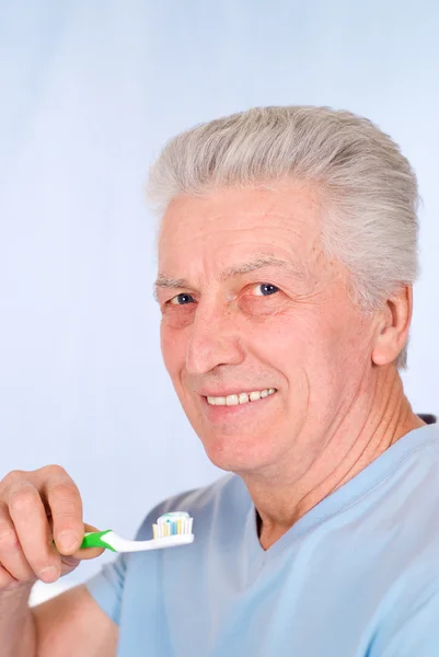 Aged guy brushes teeth — Stock Photo, Image