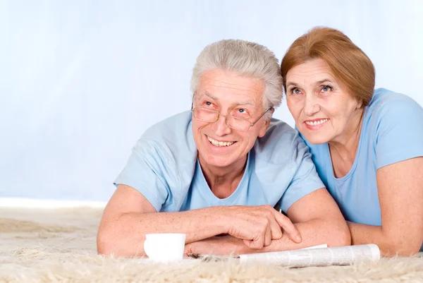 Счастливая пожилая пара с газетой — стоковое фото