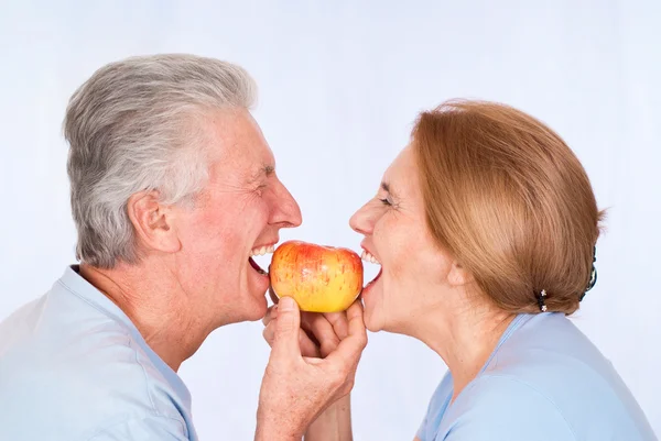 Old couple with apple — Stock Photo, Image
