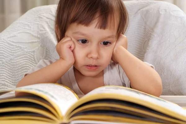 Małe dziecko kaukaski siedzi przy stole z książki — Zdjęcie stockowe