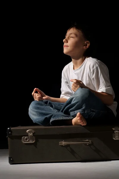 Mooie Kaukasische gelukkige jongen zittend op een koffer — Stockfoto