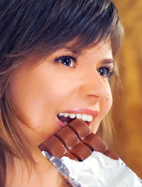 Χαριτωμένο μελαχροινή τρώει σοκολάτα — Φωτογραφία Αρχείου