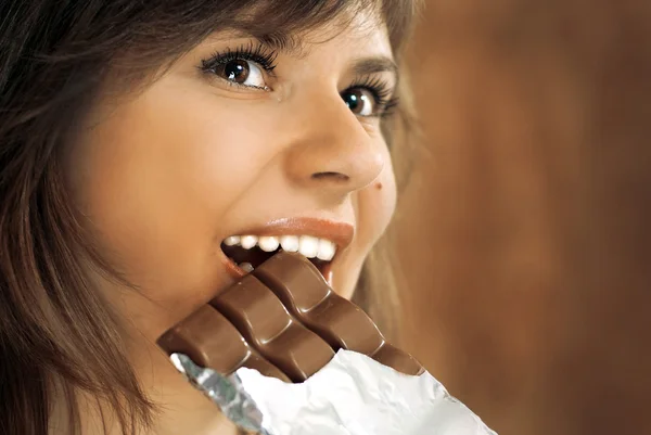 Süße Brünette isst Schokolade — Stockfoto
