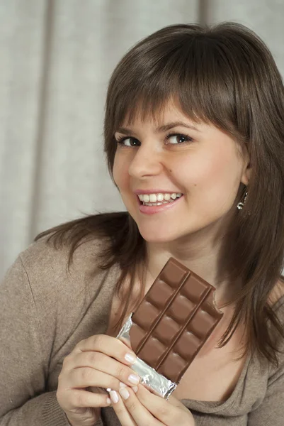Nice beautiful woman holding a chocolate bar — Stock Photo, Image
