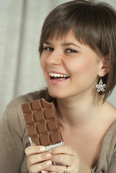 Nice sorrindo bela mulher segurando uma barra de chocolate — Fotografia de Stock