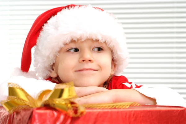 En liten unge sitter med en gåva — Stockfoto