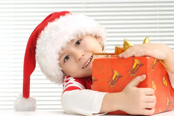 Un piccolo ragazzo si siede con un dono — Foto Stock