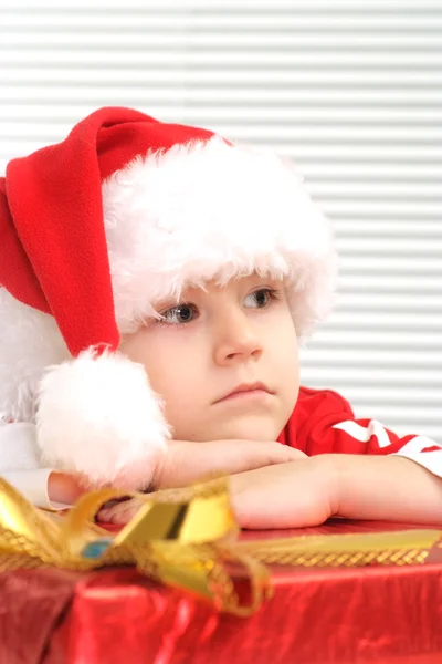 A little nice boy sits with a gift — Stock Photo, Image