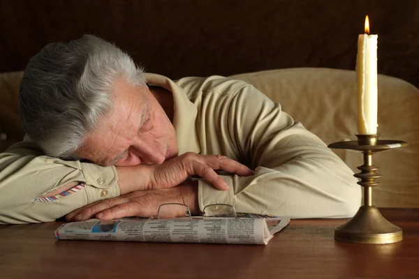 Knappe Kaukasische oudere man zit lezen van een krant — Stockfoto