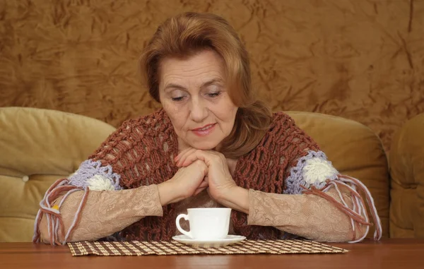 Kanepede oturan yaşlı kadın — Stok fotoğraf