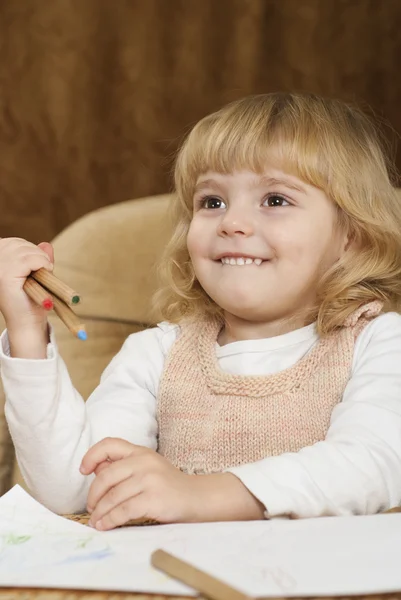La niña tiene un lápiz en la mano. — Foto de Stock