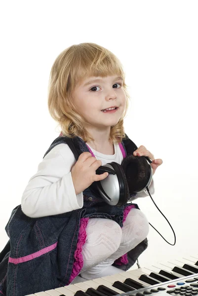 Nettes kleines Mädchen sitzt mit Kopfhörern — Stockfoto