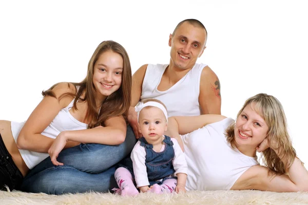 Leende familj av fyra liggande — Stockfoto