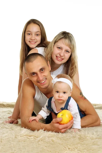Хорошая семья из четырех человек лежит на ковре — стоковое фото